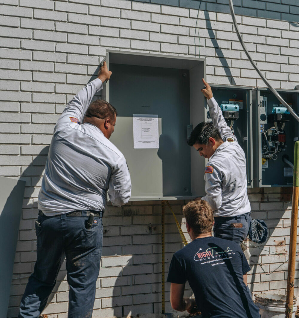 electricians measuring the size and installing the new circuit panel