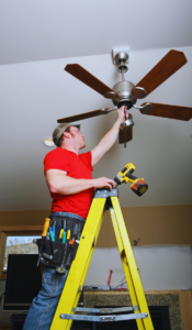 Electrician installing essential ceiling fan in Houston, TX home.