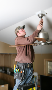 Electrician installing a code compliant permitted ceiling fan with permit 