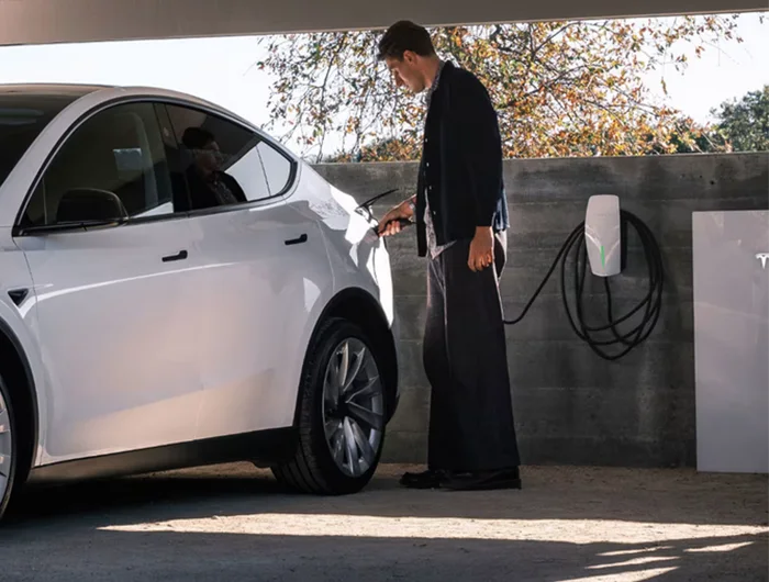 Tesla car charger with customer plugging in his Tesla model S
