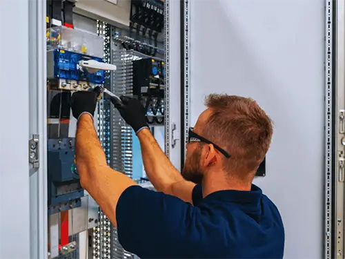 Commercial electrician servicing an electrical panel at a business in Sugarland , TX