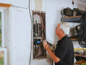Experienced electrician inspecting breaker box 