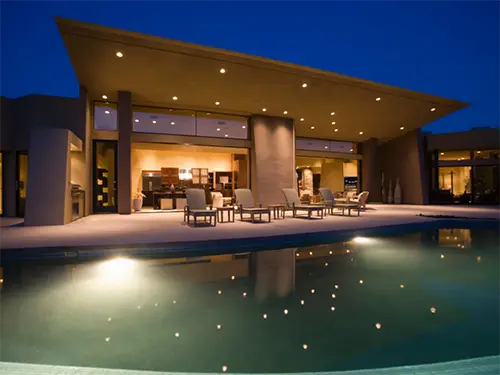 Modern outdoor lighting installation illuminating pool and patio area at night